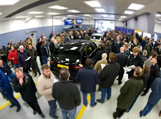 Buyers in an auction lane at Manheim stood around a vehicle