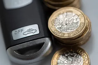 Pile of pounds coins alongside set of car keys