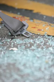 Seatbelt and broken glass on road