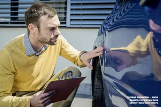 Man inspecting the panel of a car for damage
