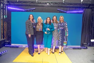 Women standing together accepting an award 