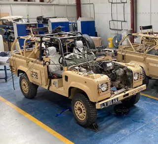 British Army Land Rover Defender with empty engine bay ready for electric conversion
