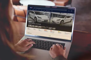 Person looking at advert for used Tesla on laptop