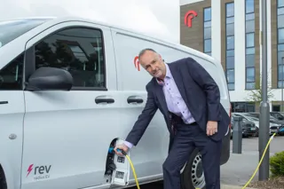 Bill Holmes, CEO of Radius, plugging in electric van