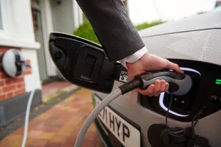 Electric car being plugged into a home charger