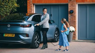 Woman plugging her electric car into a home charger