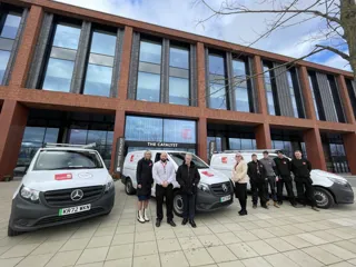 Staffordshire Uni staff outside building with vehicles 