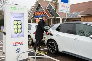 EV driver plugging in his car at a Tesco charge point