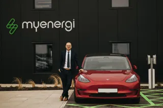 Lee Sutton, co-founder and CEO of Myenergi, outside HQ beside a charging Tesla