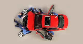 Aerial shot of people working on a car - istock