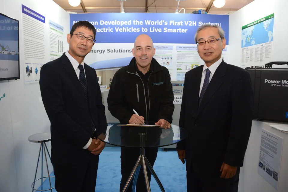 Mike Potter from DriveElectric signing the MOU for V2G chargers with Masahiro Ishiyama, senior general manager, and Hiroshi Seki, business group leader, Nichicon Corporation, at LCV2017