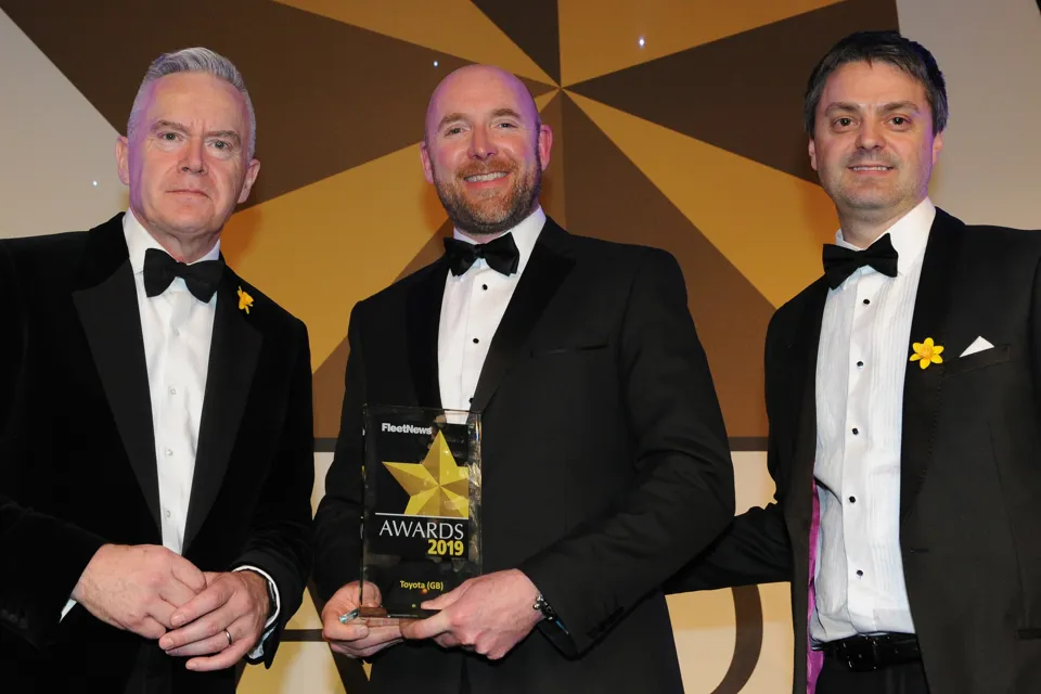 Stuart Ferma, general manager, Toyota & Lexus Fleet (centre), receiving the award with host Huw Edwards (left) and Ashley Crookes, director of sales – northern region at award sponsors Ogilvie Fleet